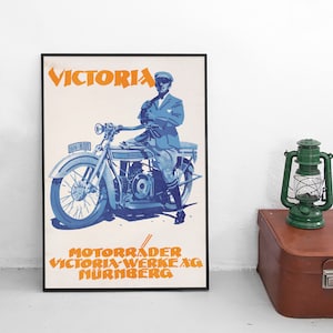 May include: A vintage poster advertising Victoria motorcycles. The poster features a blue and white illustration of a man riding a motorcycle with the text "VICTORIA" in orange letters and "MOTORRADER VICTORIA-WERKE AG NURNBERG" in orange letters at the bottom.