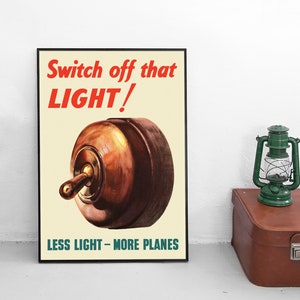 Puede incluir: Póster vintage enmarcado con el texto "Switch off that LIGHT!" en rojo, sobre una ilustración de un interruptor de luz marrón. El texto inferior dice "LESS LIGHT - MORE PLANES" en verde. Una linterna verde y una maleta marrón están a la derecha.