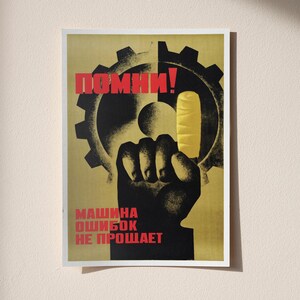 Pu&ograve; includere: Un poster rettangolare con la sagoma nera di un pugno che tiene un gelato giallo davanti a un grande ingranaggio nero. Il testo in rosso recita "ПОМНИ!" in alto e "МАШИНА ОШИБОК НЕ ПРОЩАЕТ" in basso, su uno sfondo giallo tenue.
