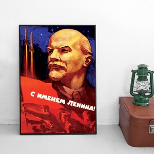 May include: A vintage Soviet propaganda poster featuring a portrait of Vladimir Lenin with the text "С именем Ленина!" (With the name of Lenin!) and two rockets launching into space.