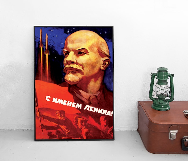May include: A vintage Soviet propaganda poster featuring a portrait of Vladimir Lenin with the text "С именем Ленина!" (With the name of Lenin!) and two rockets launching into space.