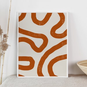 Peut inclure: Impression d'art abstrait avec un fond blanc et des lignes courbes textur&eacute;es de couleur rouille. L'&oelig;uvre est encadr&eacute;e dans un cadre blanc et expos&eacute;e sur une surface aux tons neutres. L'esth&eacute;tique g&eacute;n&eacute;rale est minimaliste et moderne.