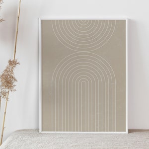 Op de afbeelding: Een ingelijst print met een beige achtergrond en witte geometrische vormen. De vormen zijn een reeks concentrische cirkels en bogen.