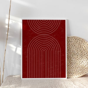 May include: A framed print with a geometric design of white arches and circles on a red background.