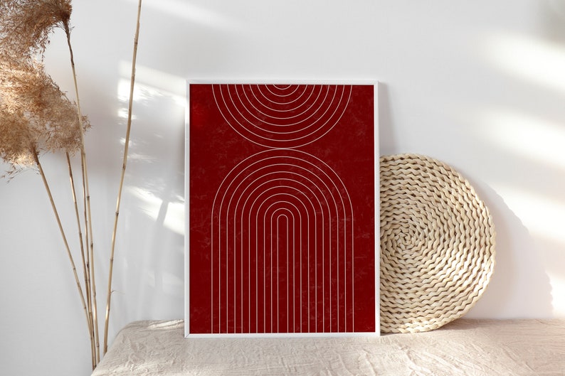 May include: A framed print with a geometric design of white arches and circles on a red background.