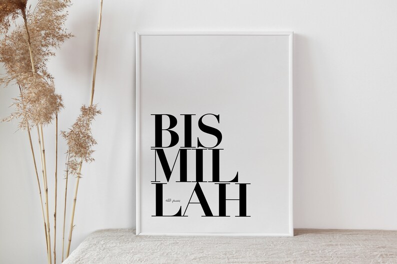 May include: A white framed print with the Arabic phrase "Bismillah" in black text. The phrase is written in a bold, modern font.