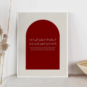 May include: A framed print with a red archway and white Arabic text. The text translates to "I seek the forgiveness of Allah the Mighty, Whom there is none worthy of worship except Him, The Living, The Eternal, and I repent unto Him."