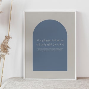 May include: Framed art print featuring Arabic calligraphy in a minimalist design. The artwork has a light gray background with a blue arch shape. The text is in Arabic and English, creating a modern and spiritual aesthetic.