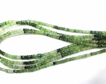 May include: A strand of green gemstone beads, with variations in shade and size. The beads are faceted and have a slightly irregular shape. The strand is approximately 18 inches long.