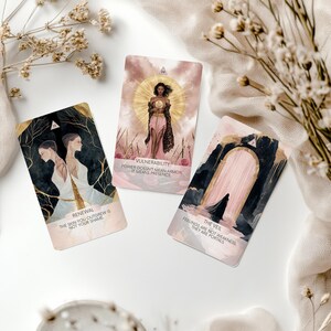 May include: Three tarot cards with illustrations and text. One card reads "Renewal," another "Vulnerability," and the third "The Veil." The cards feature gold accents and soft, pastel colors. Dried flowers and a white cloth surround the cards.