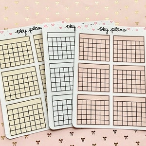 May include: Three sheets of planner stickers with gridded squares. The stickers are in three colors: yellow, white, and pink. Each sheet has the text "oky plans" written on it.