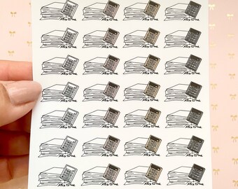 May include: A sheet of 16 black and white planner stickers featuring a stack of papers with a calculator on top. The text "oky plans" is at the top of the sheet.