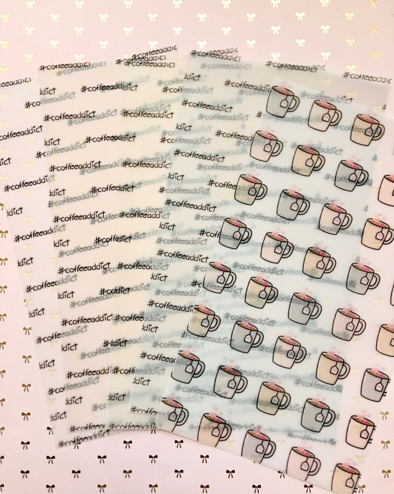 May include: Transparent sticker sheets with coffee cup illustrations, tea bags, and the text "#coffeeaddict" in black. The stickers are set against a light background with small bow patterns.