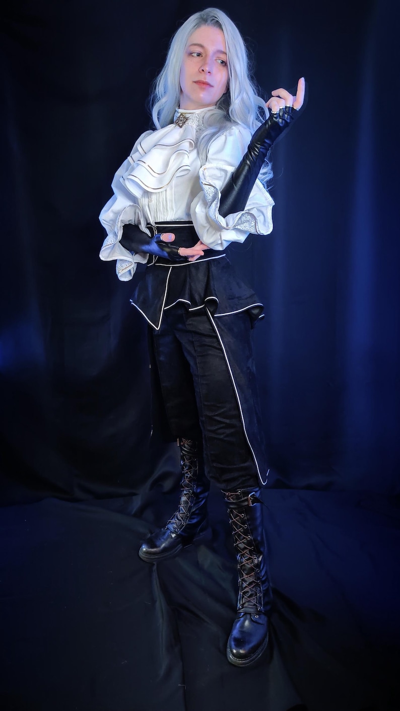 May include: A person wearing a white ruffled shirt with black accents, black pants with white trim, and black lace-up boots. The outfit has a Victorian-era aesthetic, with long black gloves and a high-collared shirt.