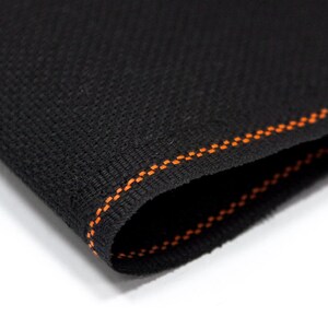 May include: Black fabric with a zig-zag orange stitch along the edge.