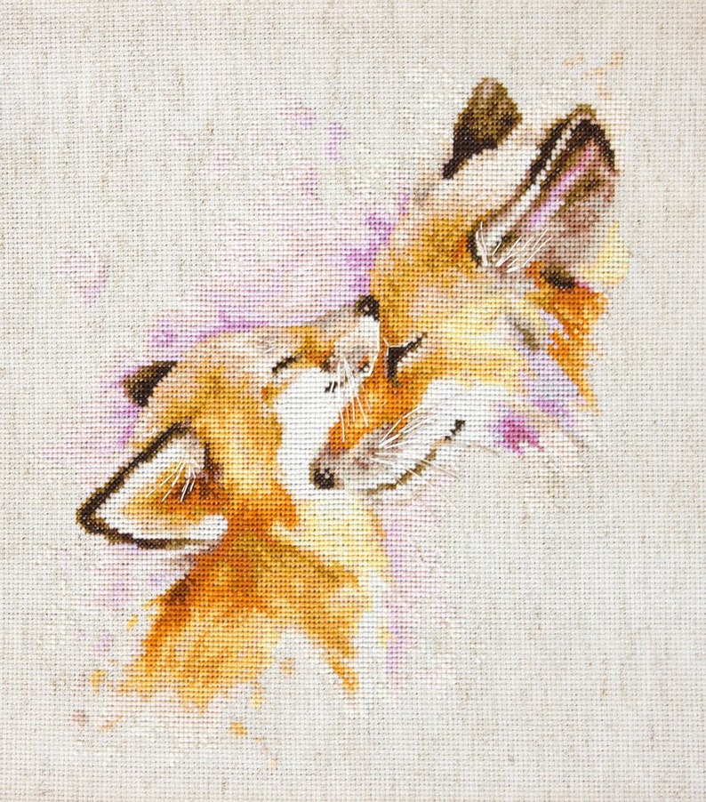 May include: Cross-stitch embroidery of two orange foxes cuddling, with a pink watercolour background.
