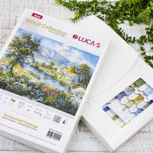 May include: A Luca-S Gold Collection cross-stitch kit depicting an "Enchanted Cottage" scene. The kit includes a box with the design and a separate box containing embroidery threads in various colours.