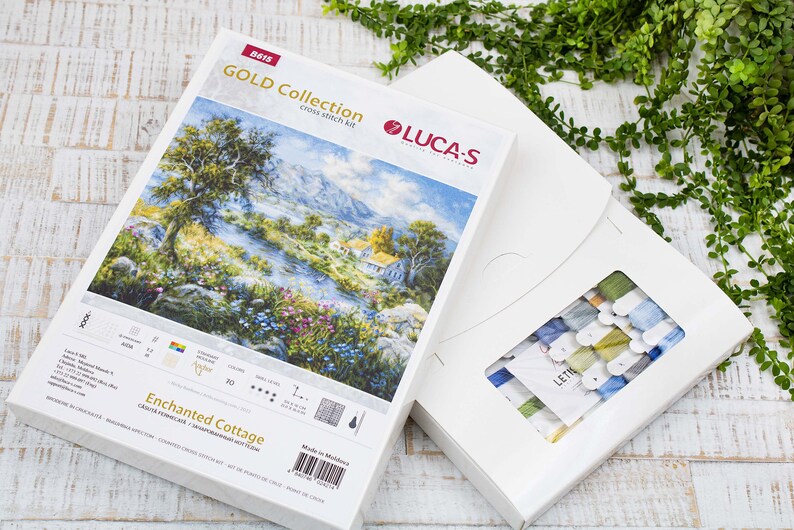 May include: A Luca-S Gold Collection cross-stitch kit depicting an "Enchanted Cottage" scene. The kit includes a box with the design and a separate box containing embroidery threads in various colours.