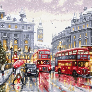 Op de afbeelding: Gedetailleerde illustratie van een besneeuwde Londense straatscène. Twee rode dubbeldekkerbussen op de natte straat, met Big Ben op de achtergrond. Mensen met paraplu's lopen langs gebouwen en een kerstboom.