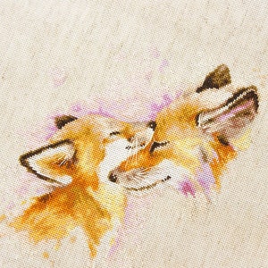 May include: Cross-stitch embroidery of two foxes cuddling, with a watercolour-like effect in shades of pink, orange, and brown.