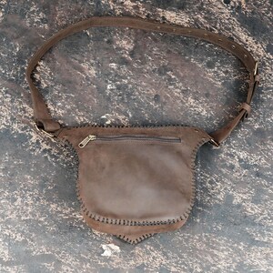 Handmade unisex leather belt bag with gemstone centerpiece and secure flap closure.