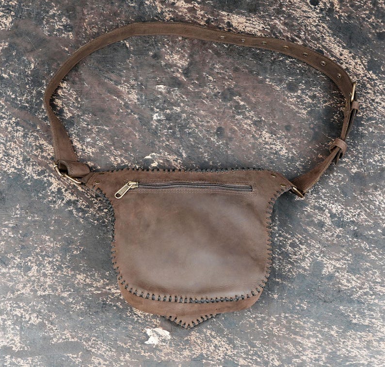 Handmade unisex leather belt bag with gemstone centerpiece and secure flap closure.