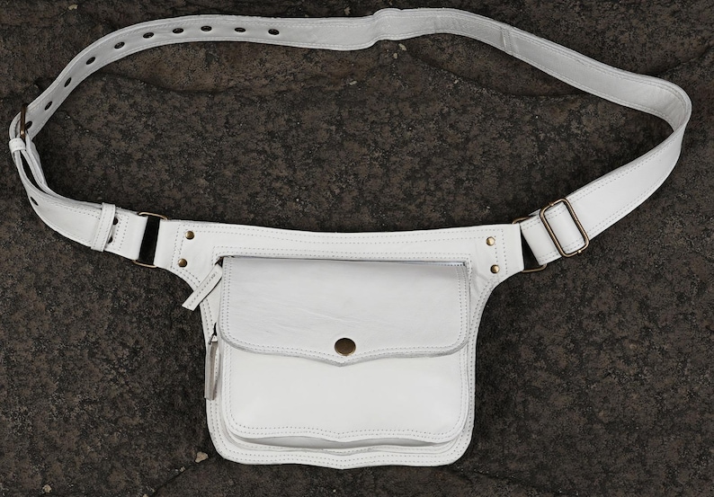 white leather waist bag showing front flap closure with metal snap button and zipper pocket for boho summer festival style.