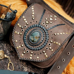 Boho steampunk leather waist bag featuring gemstone centerpiece and decorative stitching.