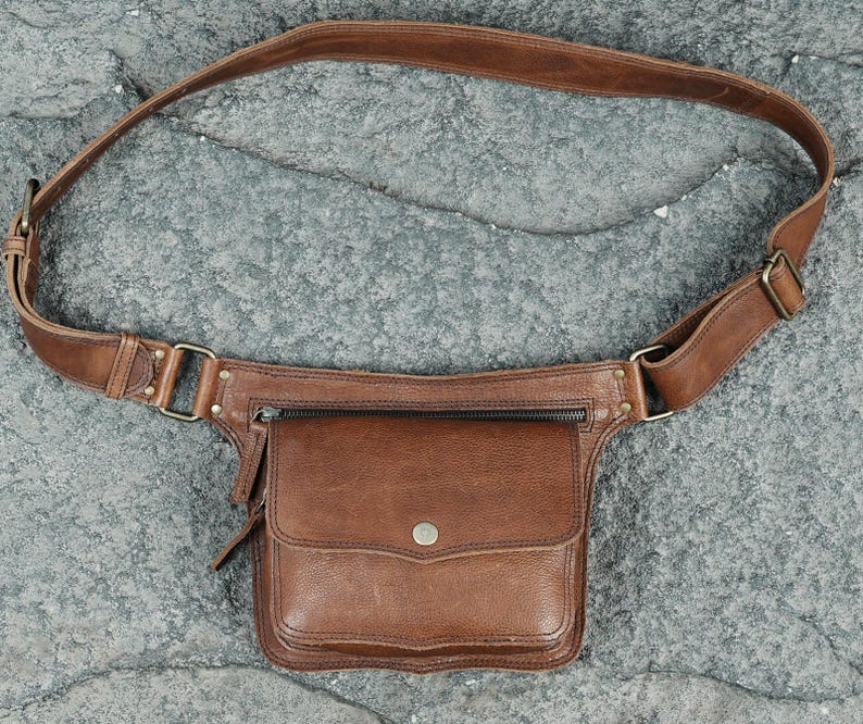 Handmade brown leather utility pocket belt with front flap pocket, metal snap closure, and antique brass hardware for bohemian style.