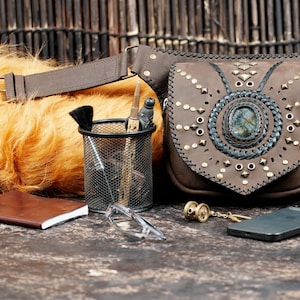 Handmade gemstone belt bag with tan leather, braided edges, and adjustable fit.