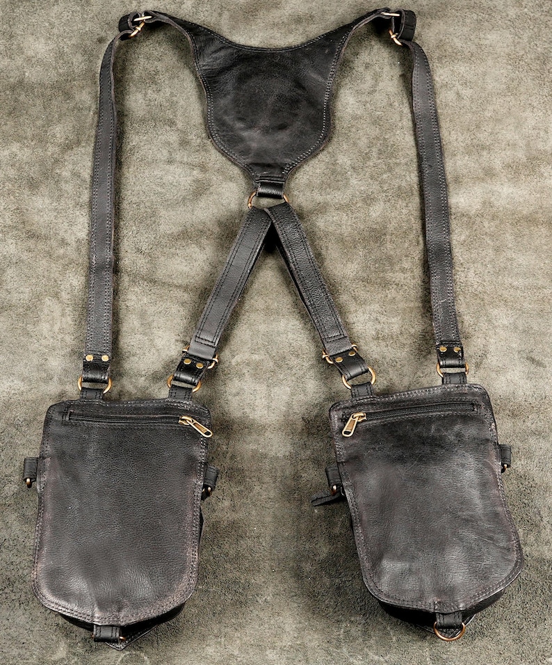 Plain rear finish of black dual holster pouches showing hidden zippered security pockets and smooth harness straps.