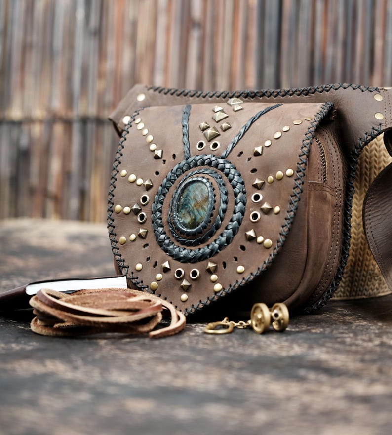 Handmade leather festival belt bag with gemstone centerpiece and brass rivets.