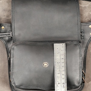 Black handmade leather hip bag shown open with a ruler measuring the front pocket height at 5 inches (13 cm)

leather hip bag, utility belt bag, festival hip bag, drop leg bag, thigh holster bag, steampunk hip pouch, black waist bag, handmade belt purse, biker thigh pack, gothic waist pouch, rave utility pack, leather fanny pack, burning man gear