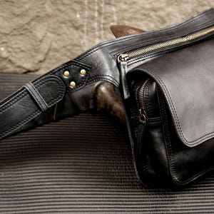 Handcrafted black leather fanny pack with brass hardware and adjustable waist belt