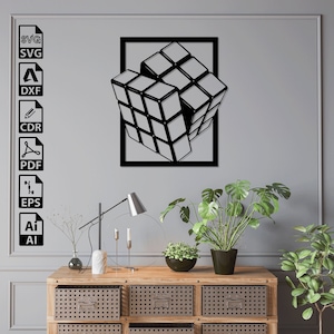 Puede incluir: Una escultura de pared de metal negro de un cubo de Rubik 3D, con un fondo gris y una cómoda de madera con cajones en primer plano.