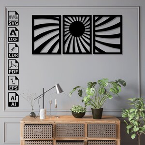 May include: Three black metal wall art pieces with a sunburst design. The center piece features a large black circle in the middle of the sunburst. The pieces are arranged in a row on a gray wall.