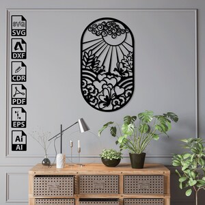 Può includere: Arte da parete in metallo nero con un sole stilizzato, nuvole e fiori. L'arte ha una forma ovale ed è appesa a una parete grigia.