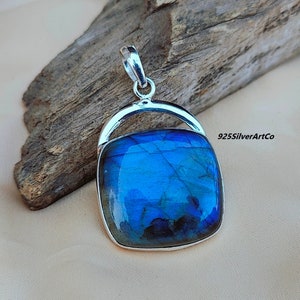 May include: A silver pendant with a square blue labradorite gemstone. The pendant has a simple design with a silver bail.
