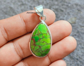May include: A teardrop-shaped pendant with a green turquoise stone set in sterling silver. The stone has a mottled green and brown pattern.
