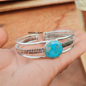 May include: Silver bangle bracelet with a turquoise stone. The bracelet has a textured design and is made of three bands.