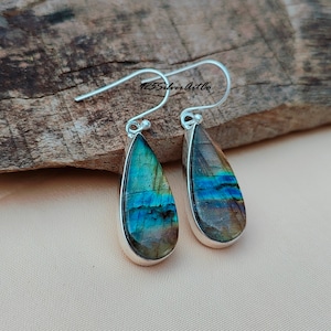 May include: A pair of silver teardrop earrings with iridescent blue and green labradorite stones.