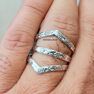 Op de afbeelding: Drie zilveren ringen met een bloemmotief. De ringen zijn op elkaar gestapeld en worden aan een vinger gedragen. De ringen zijn gemaakt van 925 sterling zilver en zijn een populaire keuze voor vrouwen.