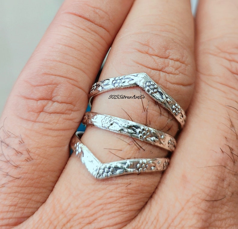Op de afbeelding: Drie zilveren ringen met een bloemmotief. De ringen zijn op elkaar gestapeld en worden aan een vinger gedragen. De ringen zijn gemaakt van 925 sterling zilver en zijn een populaire keuze voor vrouwen.