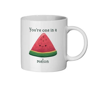 Op de afbeelding: Witte keramische mok met een watermeloenafbeelding en de tekst "You're one in a melon".