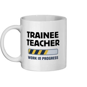 Könnte beinhalten: Eine weiße Keramik-Kaffeetasse mit schwarzem Text, der "Trainee Teacher" lautet, und einer Fortschrittsanzeige mit gelben und schwarzen Streifen. Der Text "Work in Progress" befindet sich unter der Fortschrittsanzeige.