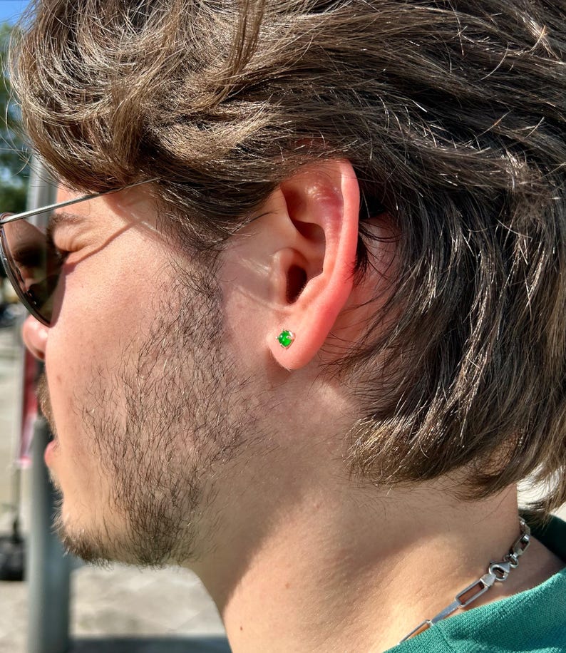 A 925 sterling silver men’s stud earring with a deep green stone, shown in close-up against a dark background. Minimalist and stylish, ideal for men’s everyday jewelry.