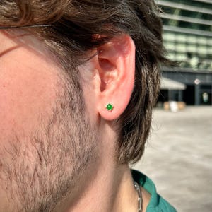 A 925 sterling silver men’s stud earring with a deep green stone, shown in close-up against a dark background. Minimalist and stylish, ideal for men’s everyday jewelry.