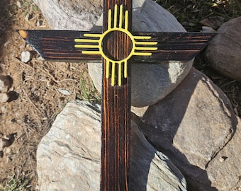 Cruz amarilla con el símbolo Zia