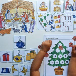 May include: A selection of Christmas-themed educational toys. Includes a Christmas tree with numbers, puzzle pieces, and cards with festive images. The scene also features a nativity scene and other holiday-related illustrations.