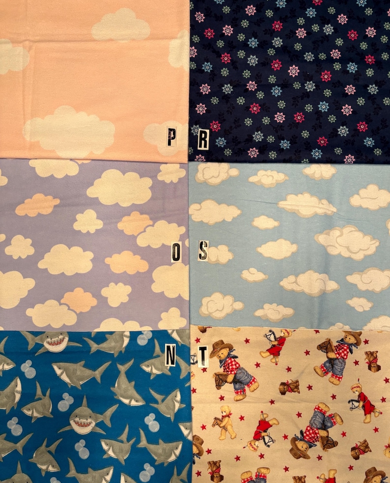 Op de afbeelding: Een collectie van zes stoffen stalen met verschillende patronen: perzik met witte wolken, donkerblauw met kleine bloemmotieven, lichtpaars met witte wolken, lichtblauw met witte wolken, blauw met grijze haaien en beige met teddyberen.